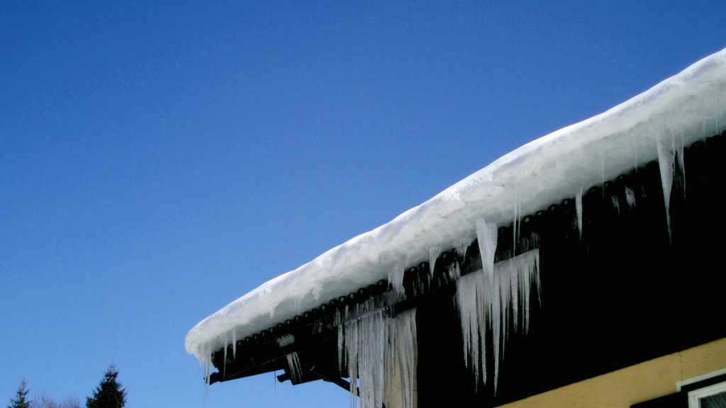 Dellen von Eiszapfen entstehen im Winter, wenn sie an einem Dach hängen