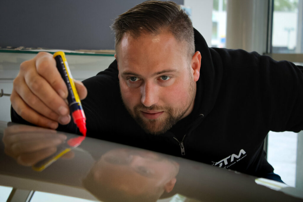 MMst. Florian Marko, Inhaber der Firma DTM (Dellen-Technik-Marko), Mitglied im Dellenteam, beim Anzeichnen der Dellen für die Hagelschadenreparatur